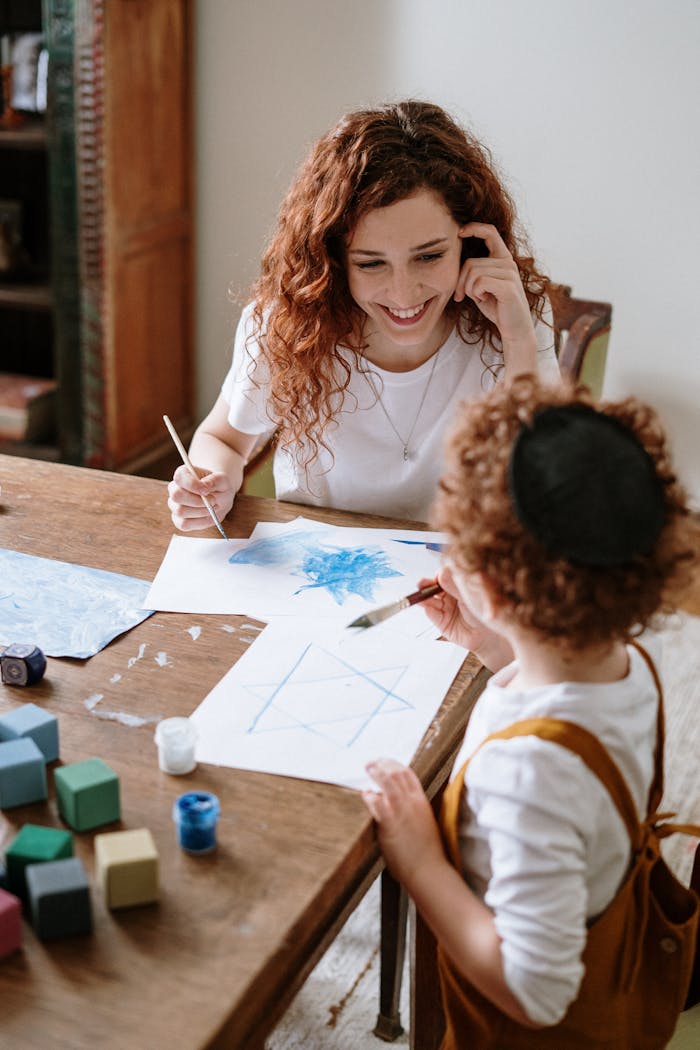 A mother and child bonding while painting together at home.