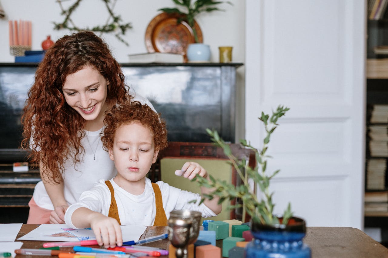 A joyful mother and son drawing together at home, surrounded by colors and creativity.